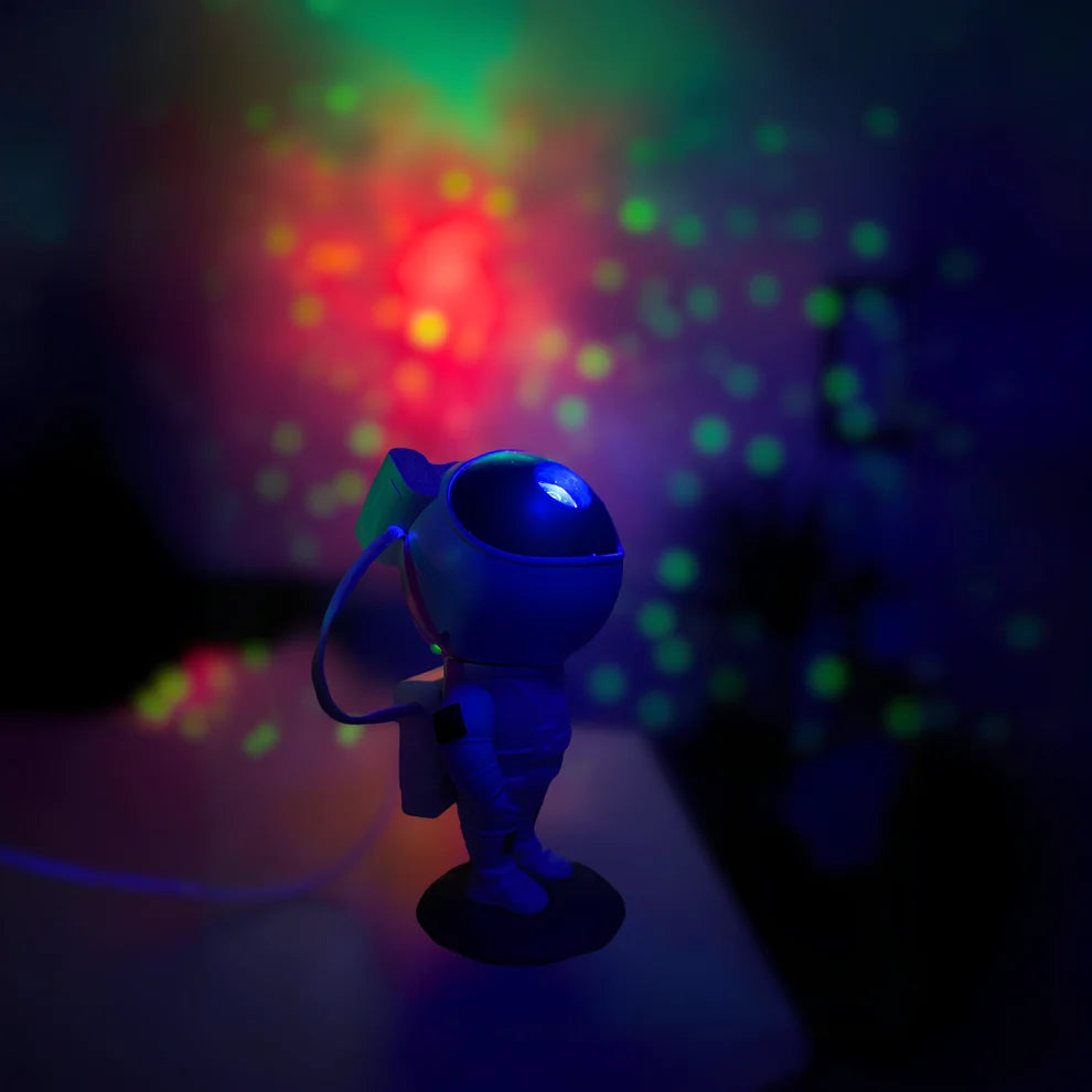 Astronaut projector lighting the wall with multicolor nebula effects and stars