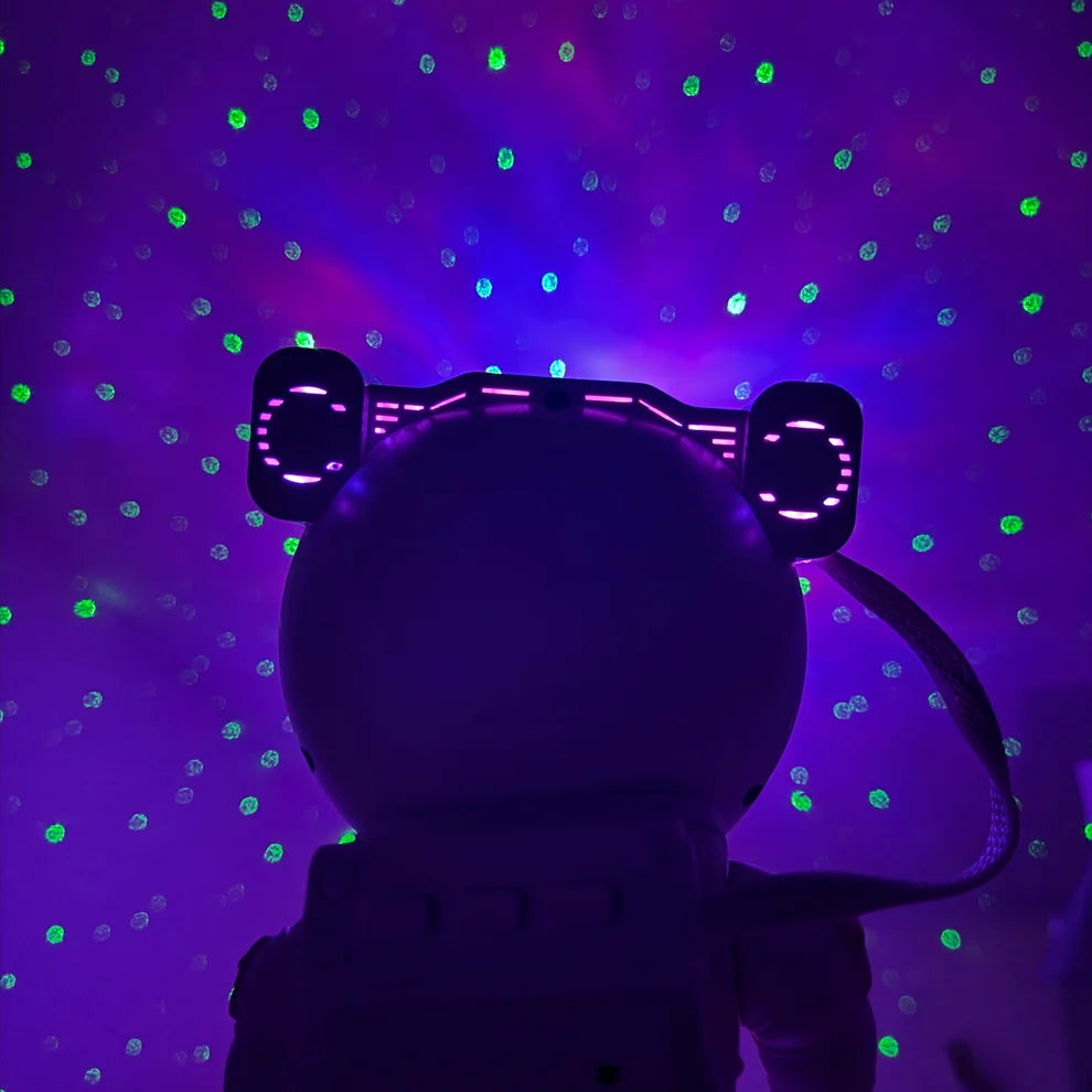 Purple nebula and green stars projected above the astronaut projector